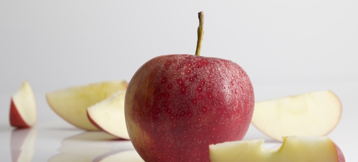 Ganze und geschnittene rote Äpfel auf weißem Hintergrund.